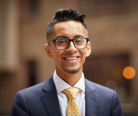 Young adult in glasses, blue jacket and tie