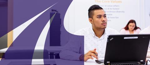 Young man in white shirt sitting in front of laptop computer