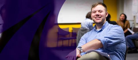 Young man in blue shirt sitting and smiling